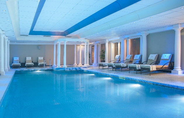 indoor pool with coloums around jacuzzi