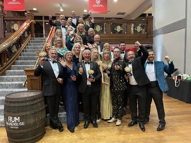 group of people posing for picture cheering award win 